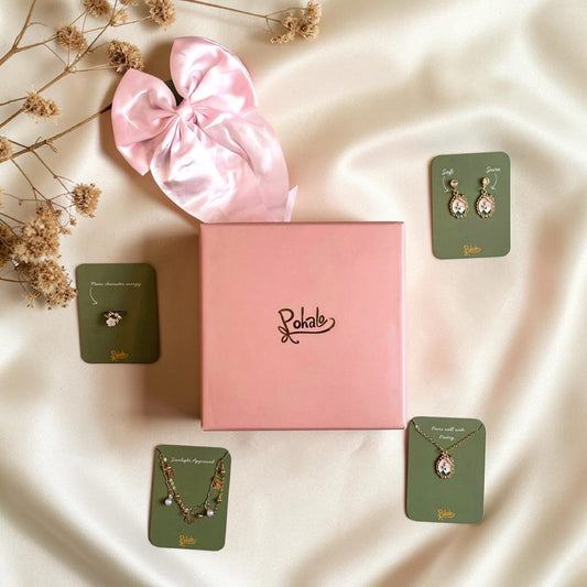 Jewellery set with a pink satin bow and 'Pohalo' branding on a soft fabric background. Set of 5 products