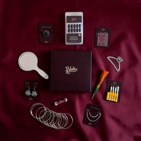 Collection of jewelry and accessories on a maroon fabric background